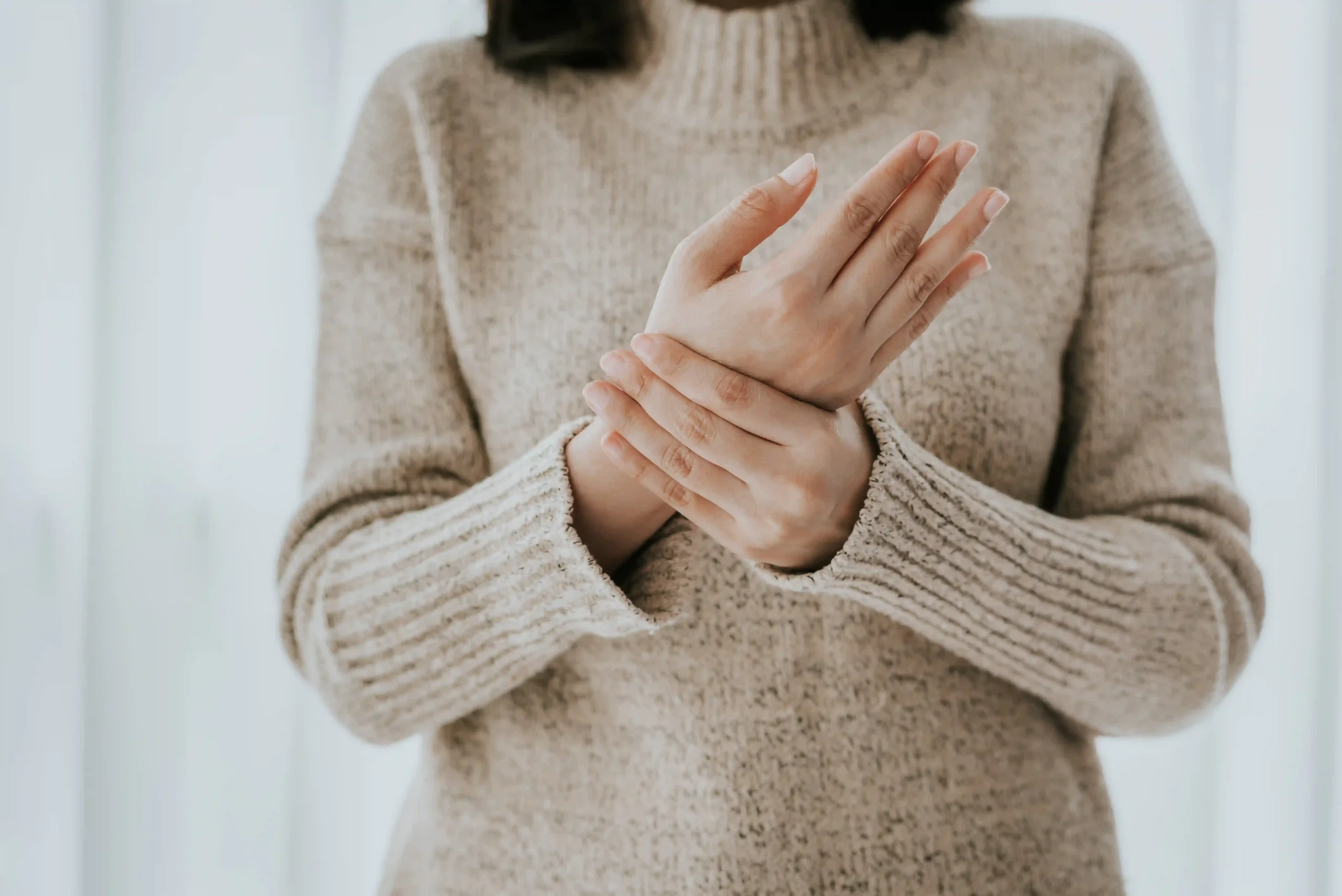 Woman holding her painful wrist, a common area affected by complex regional pain syndrome.