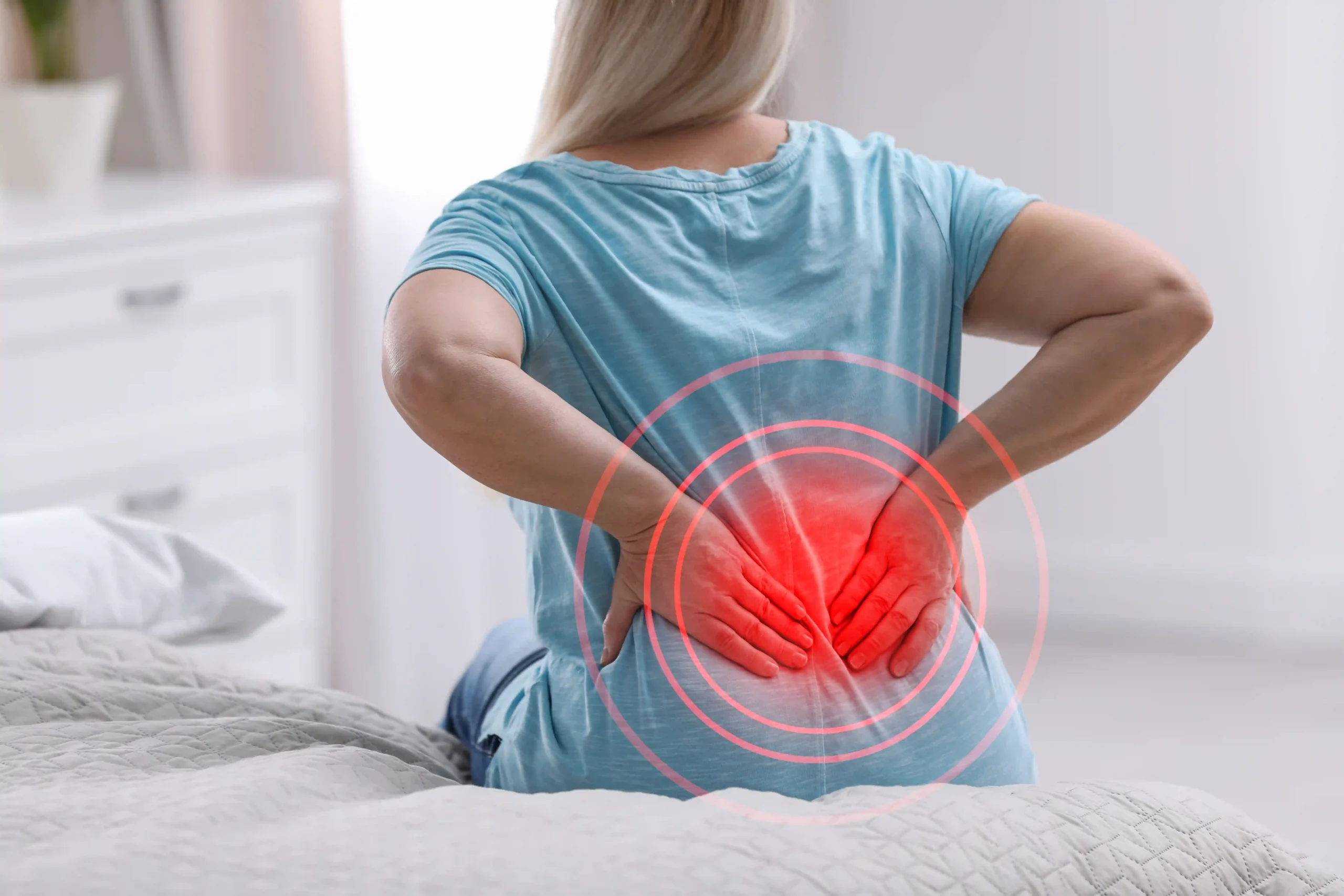 Woman holding her lower back with a red graphic highlighting persistent back pain.